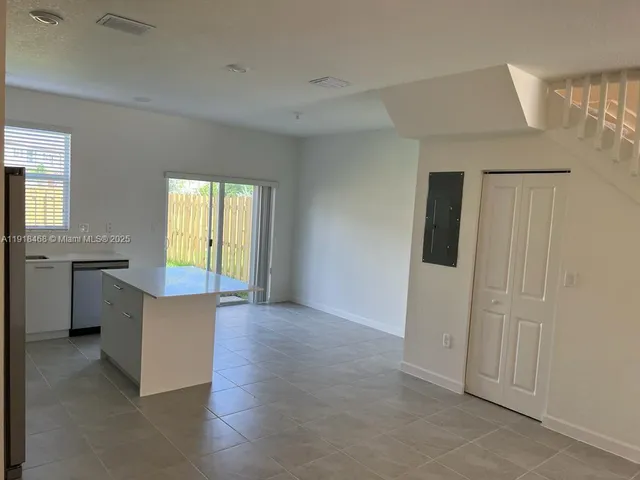 a kitchen with a sink a microwave a refrigerator and cabinets