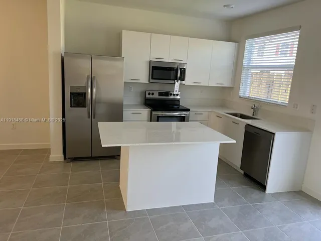 a kitchen with stainless steel appliances a stove a sink and a refrigerator