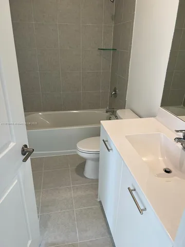 a white toilet sitting next to a bath tub