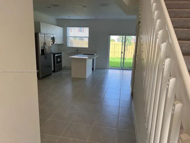 a kitchen with stainless steel appliances a refrigerator a sink a stove a microwave a counter top and cabinets