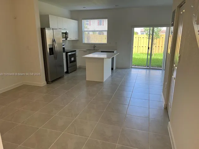 a kitchen with stainless steel appliances a stove a sink a microwave and a refrigerator