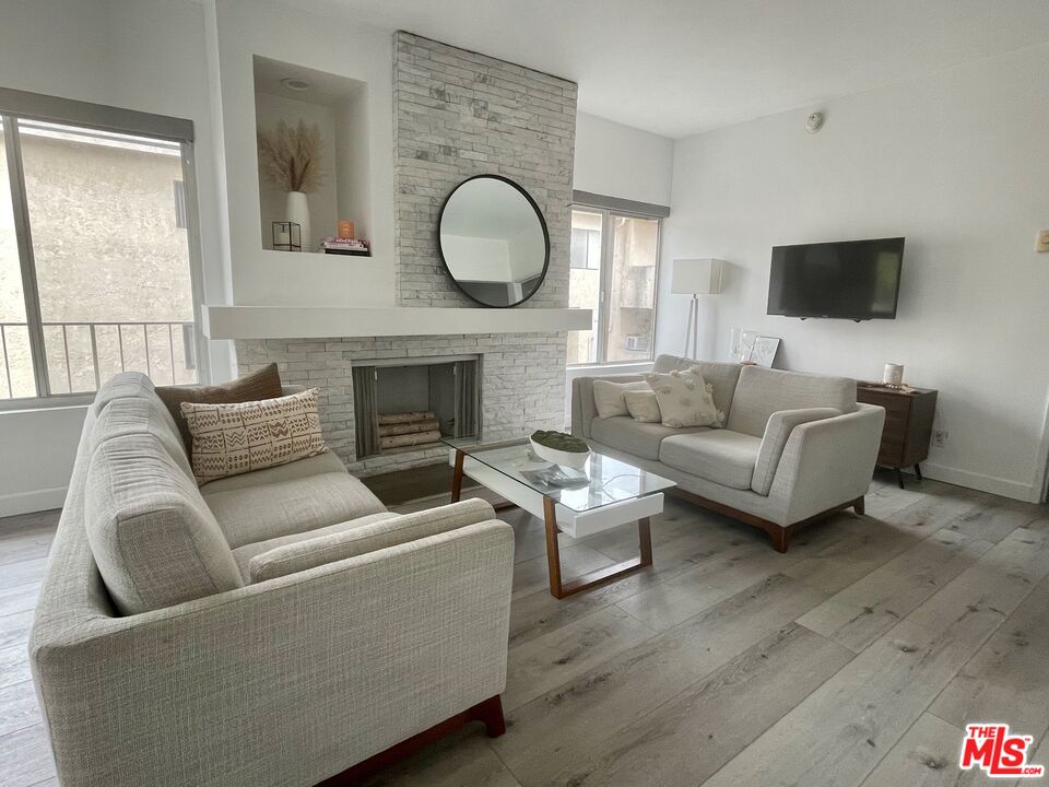 11906 Gorham Avenue, Unit 4 Los Angeles, CA 90049 - Photo 1 of 11 a living room with furniture a flat screen tv and a fireplace