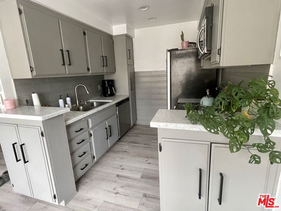 11906 Gorham Avenue, Unit 4 Los Angeles, CA 90049 - Photo 5 of 11 a kitchen with stainless steel appliances a refrigerator sink and cabinets