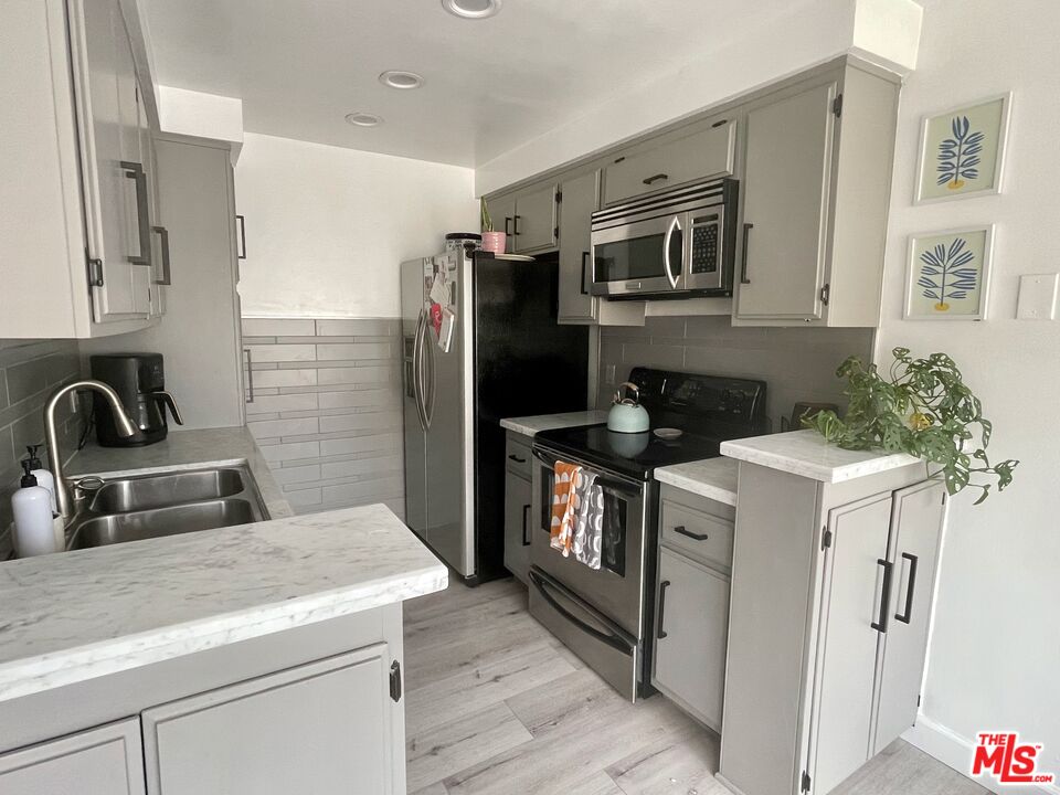 11906 Gorham Avenue, Unit 4 Los Angeles, CA 90049 - Photo 6 of 11 a kitchen with stainless steel appliances granite countertop a refrigerator a stove a sink and a microwave