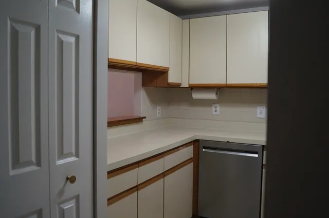 a kitchen with a white cabinets and a refrigerator