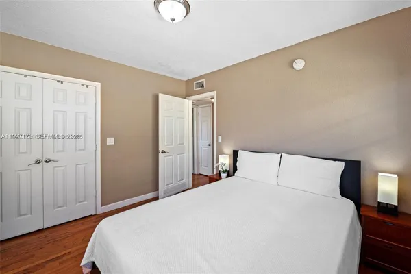 a bedroom with a bed and wooden floor