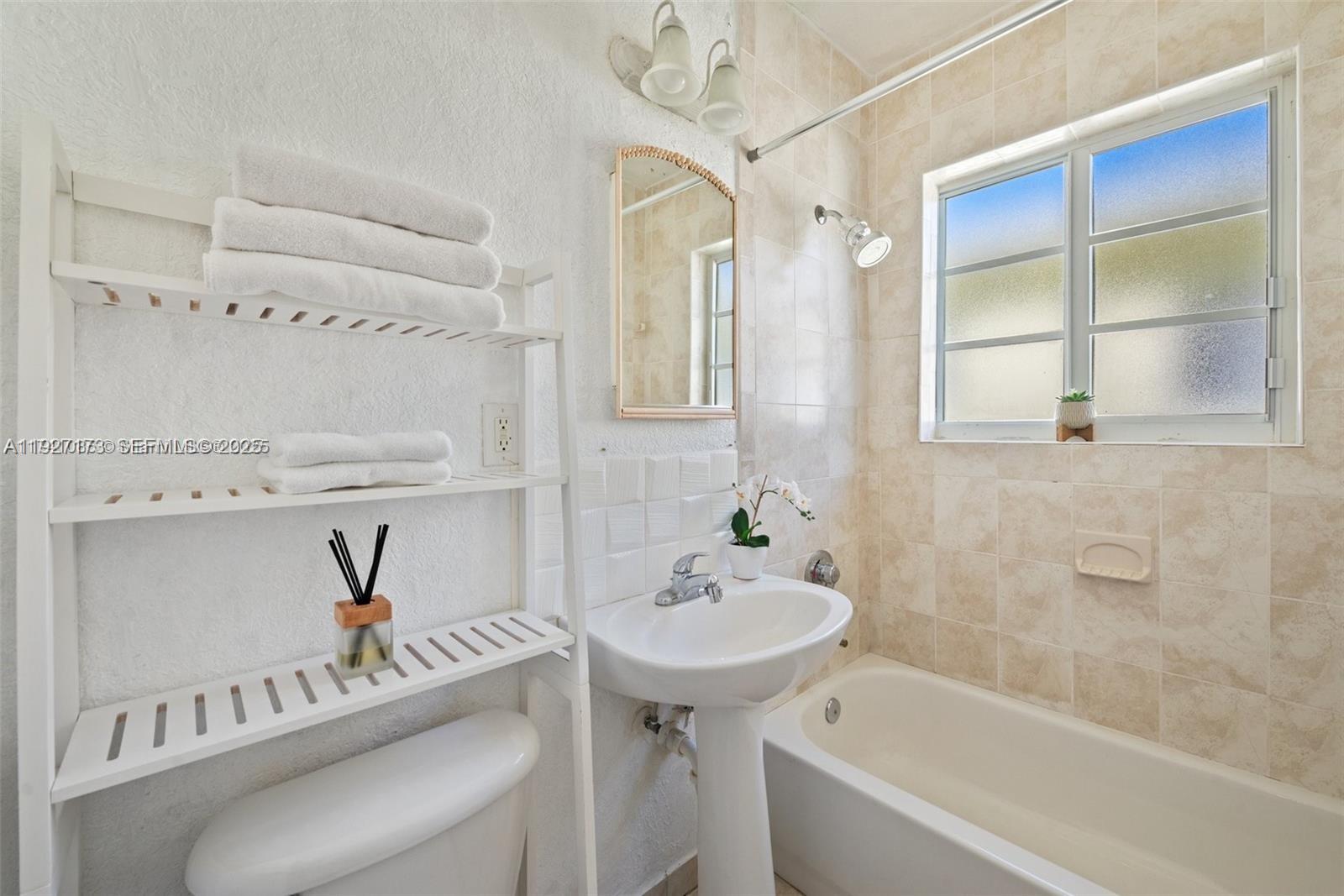 8345 Byron Avenue, Unit 6 Miami Beach, FL 33141 - Photo 19 of 23 a bathroom with a sink a bathtub and a window