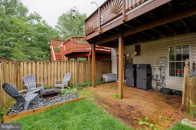 a backyard of a house with barbeque oven table and chairs