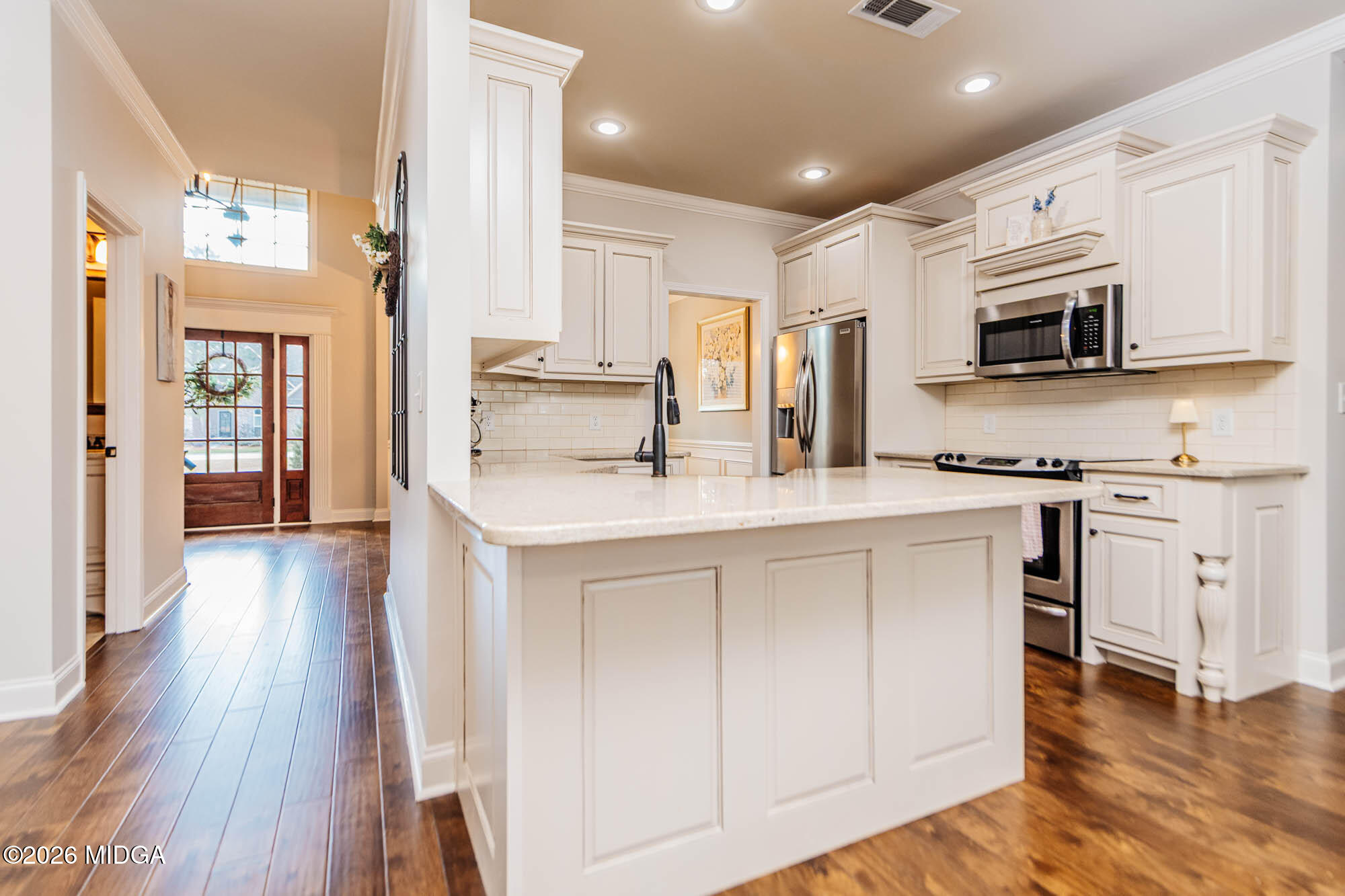 112 Bainbridge Lane Perry, GA 31069 - Photo 11 of 37 a kitchen with stainless steel appliances a microwave a stove a sink dishwasher and a refrigerator with wooden floor