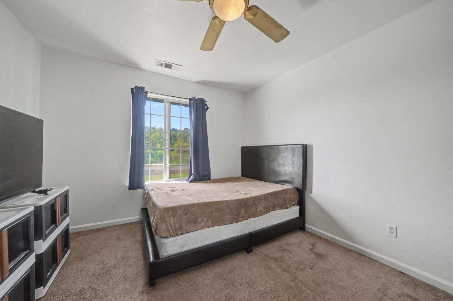 7761 Jenny Lind Road Valley Springs, CA 95252 - Photo 25 of 35 a bedroom with a bed and a flat screen tv