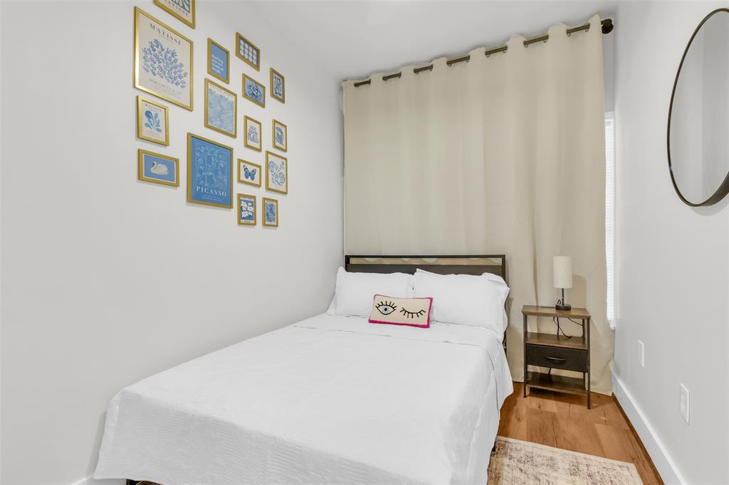 4121 Junius Street, Unit 4123 Dallas, TX 75246 - Photo 21 of 23 a bedroom with a bed and a mirror
