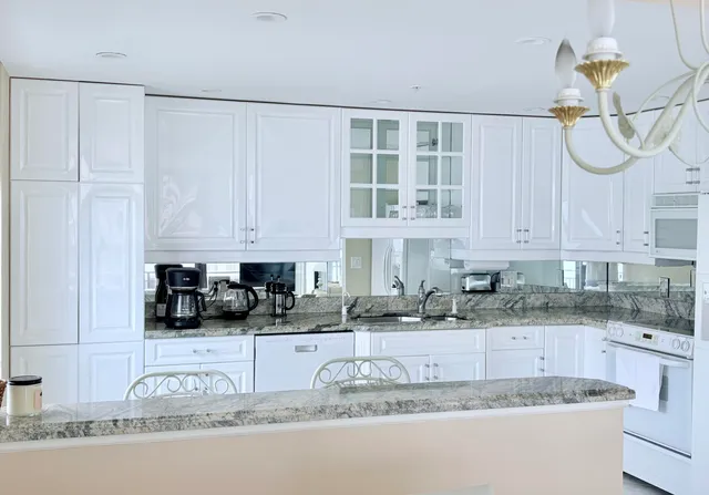 a kitchen with granite countertop a sink a stove and cabinets