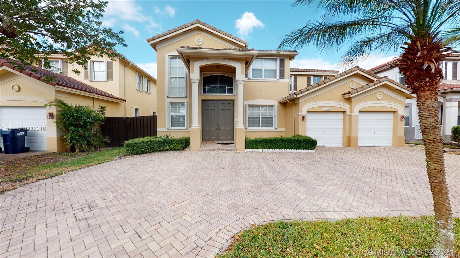 12355 Southwest 124th Terrace Miami, FL 33186 - Photo 2 of 61 a front view of a house with a yard and garage