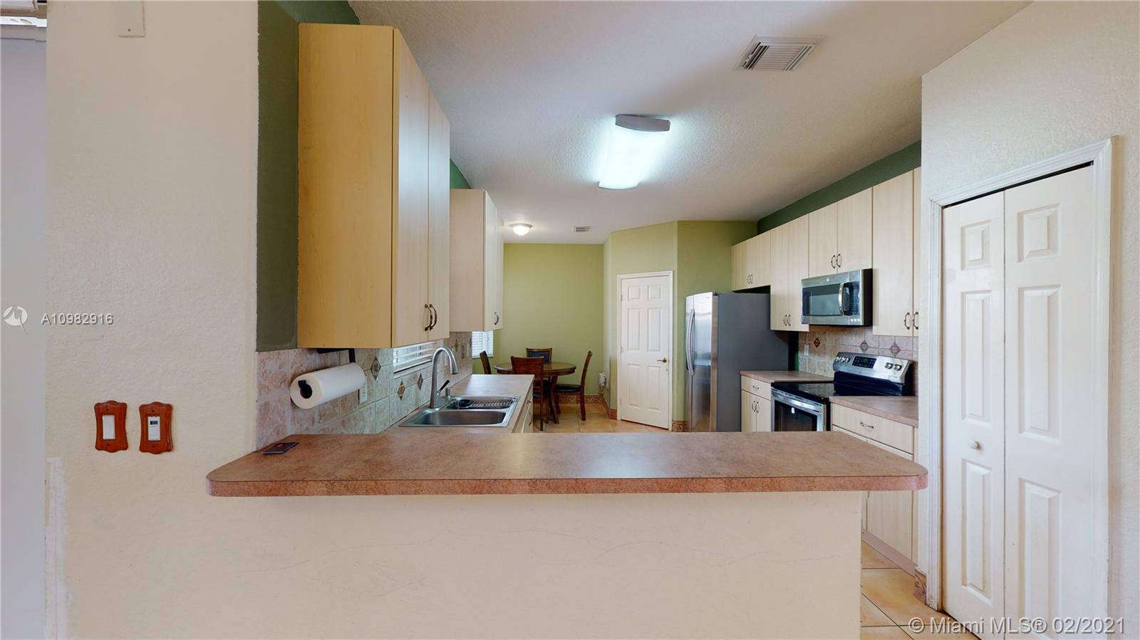 12355 Southwest 124th Terrace Miami, FL 33186 - Photo 17 of 61 a kitchen with kitchen island a sink appliances and cabinets