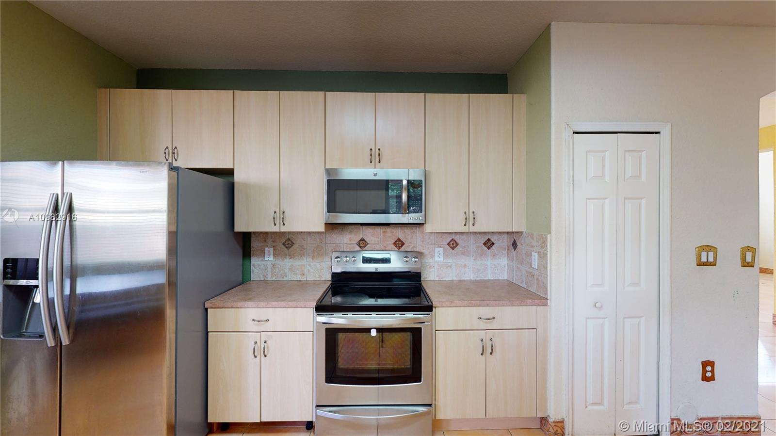 12355 Southwest 124th Terrace Miami, FL 33186 - Photo 22 of 61 a kitchen with stainless steel appliances a stove a microwave and a refrigerator