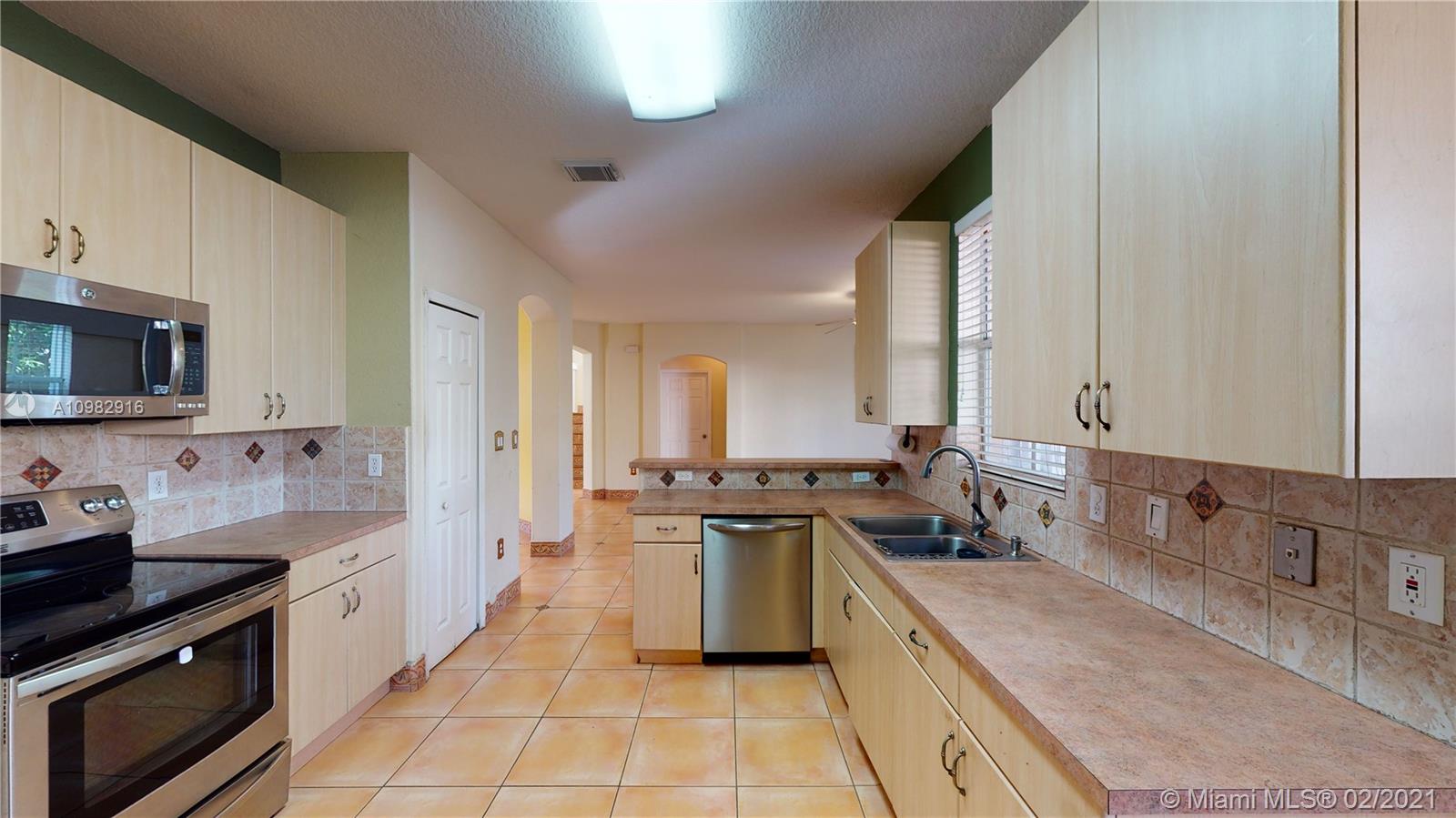 12355 Southwest 124th Terrace Miami, FL 33186 - Photo 23 of 61 a large kitchen with stainless steel appliances granite countertop a sink stove and refrigerator