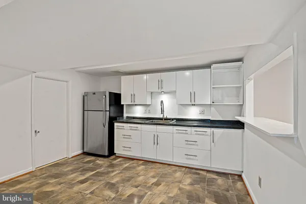 a kitchen with white cabinets and refrigerator