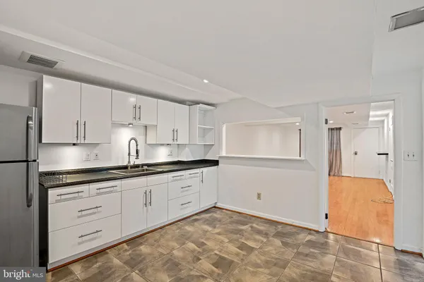 a kitchen with granite countertop white cabinets and white appliances