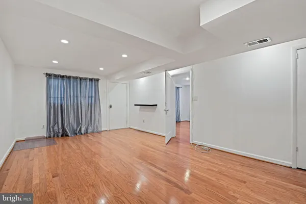 a view of an empty room with wooden floor