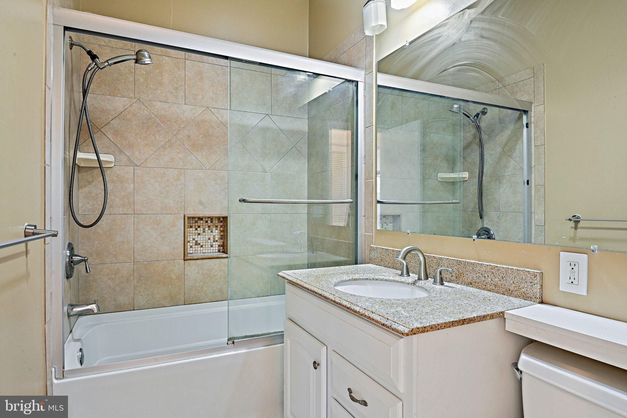6713 Old Chesterbrook Road McLean, VA 22101 - Photo 26 of 38 a bathroom with a granite countertop sink a shower and a mirror