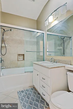 a bathroom with a granite countertop sink a toilet and shower