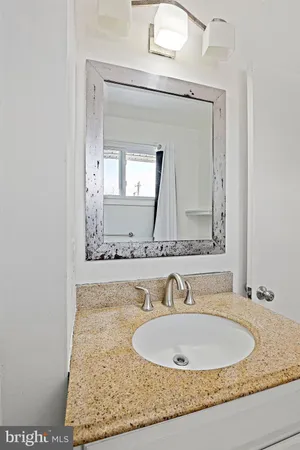 a bathroom with a granite countertop sink and a mirror