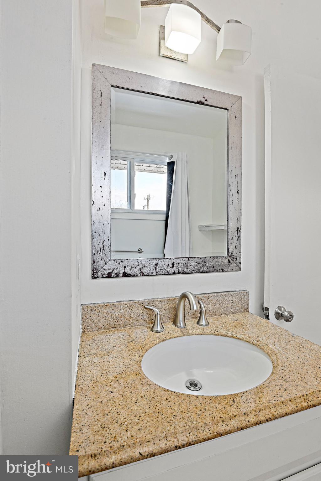 6713 Old Chesterbrook Road McLean, VA 22101 - Photo 32 of 38 a bathroom with a granite countertop sink and a mirror