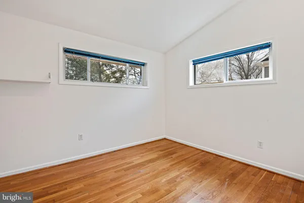 a view of empty room with wooden floor