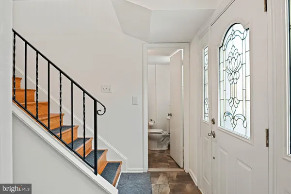 a view of a hallway with wooden floor and stairs