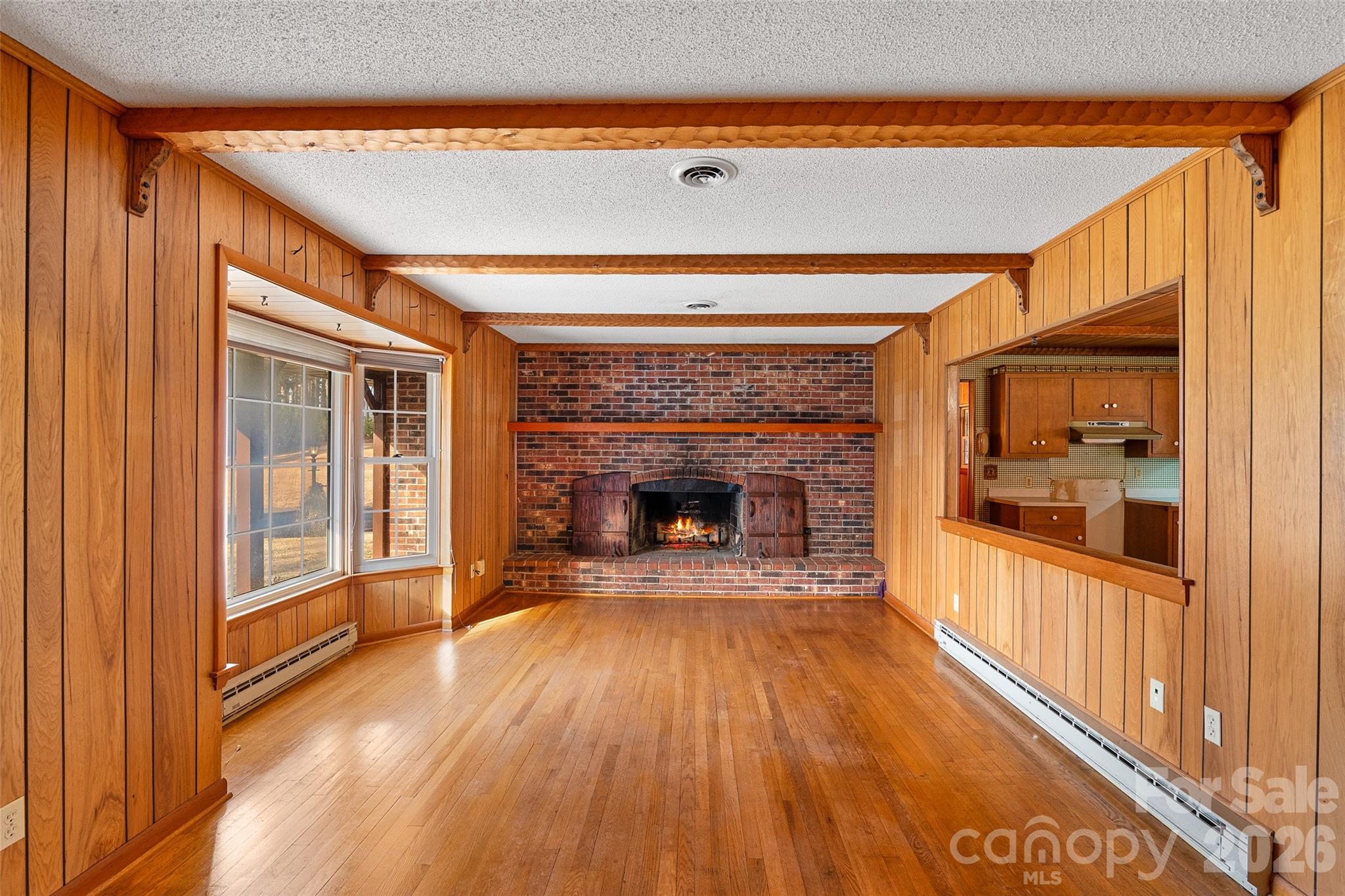 591 Landrum Road Tryon, NC 28782 - Photo 16 of 48 a view of a livingroom with wooden floor a fireplace and windows