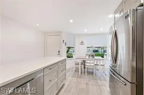 a kitchen with stainless steel appliances a refrigerator and a table