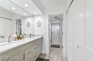 a bathroom with a double vanity sink and mirror with shower