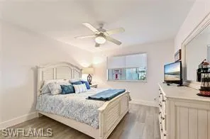 a bedroom with a large bed a flat tv screen and a dresser