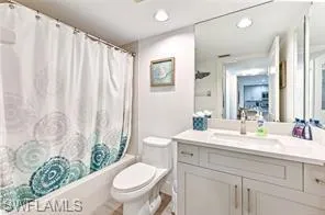 a bathroom with a sink a toilet and shower curtain