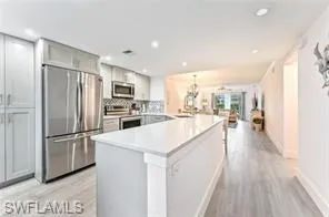 a kitchen with kitchen island a counter top space a sink and stainless steel appliances