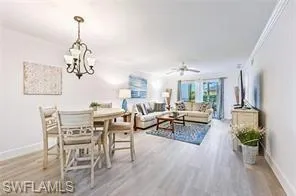 a living room with furniture dining table and a chandelier