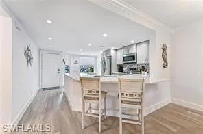 a kitchen with kitchen island white cabinets and stainless steel appliances