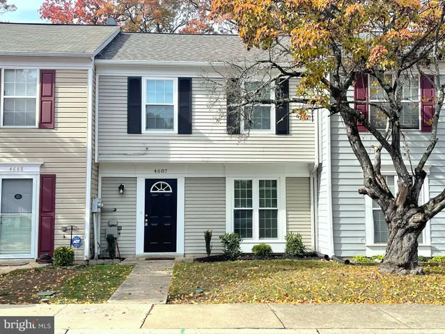 a view of a brick house with a large windows and a large tree