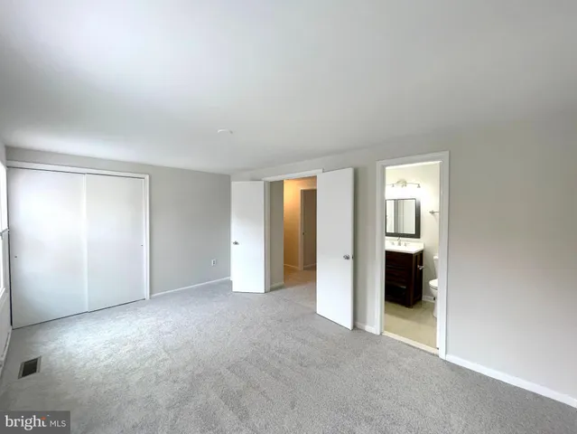 an empty room with windows and closet