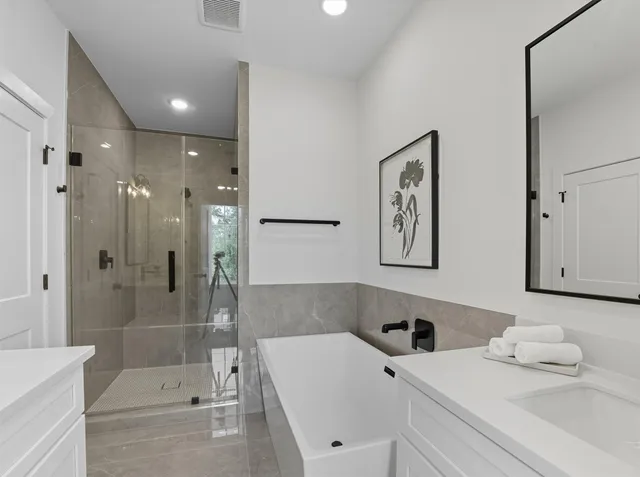a bathroom with a tub sink and mirror