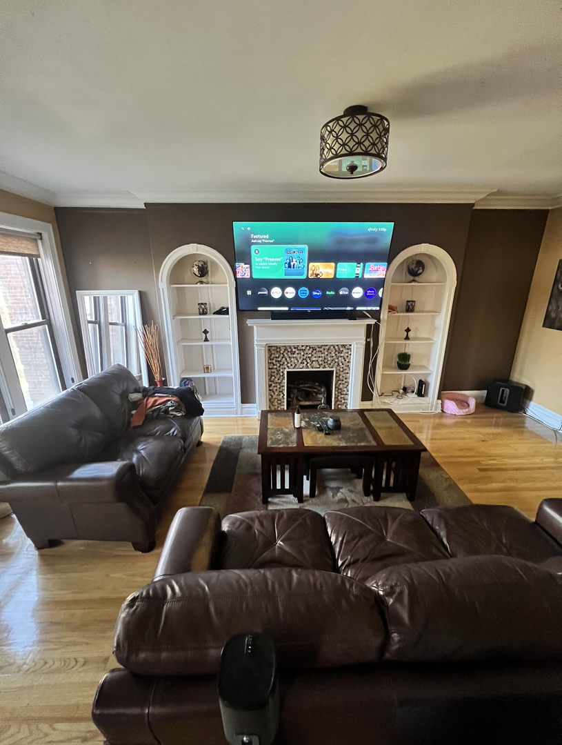 6830 South Paxton Avenue, Unit 3A Chicago, IL 60649 - Photo 2 of 8 a living room with furniture and a fireplace