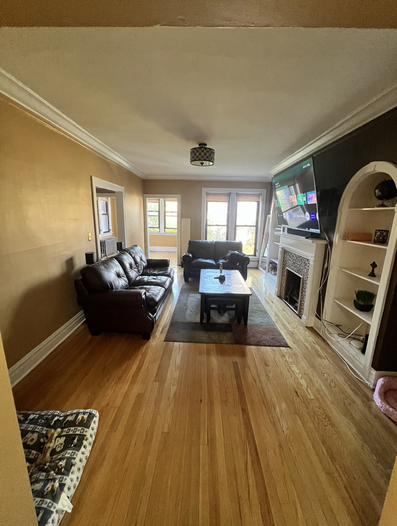6830 South Paxton Avenue, Unit 3A Chicago, IL 60649 - Photo 3 of 8 a living room with furniture and a flat screen tv