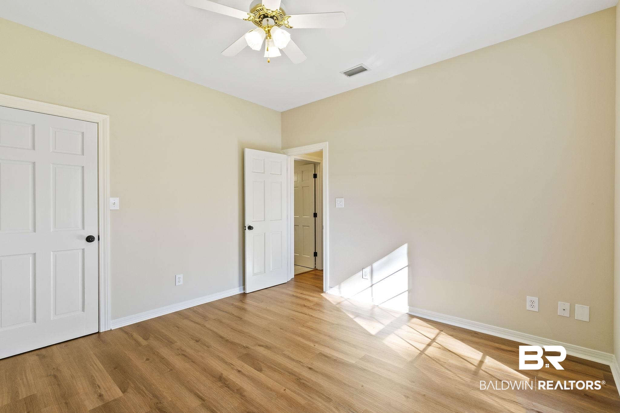 9631 Bay Meadows Avenue Fairhope, AL 36532 - Photo 28 of 49 Unfurnished bedroom featuring light hardwood / wood-style flooring, ceiling fan, and large walk-in closet with shelving.