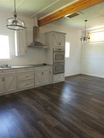 a room with wooden floors and windows