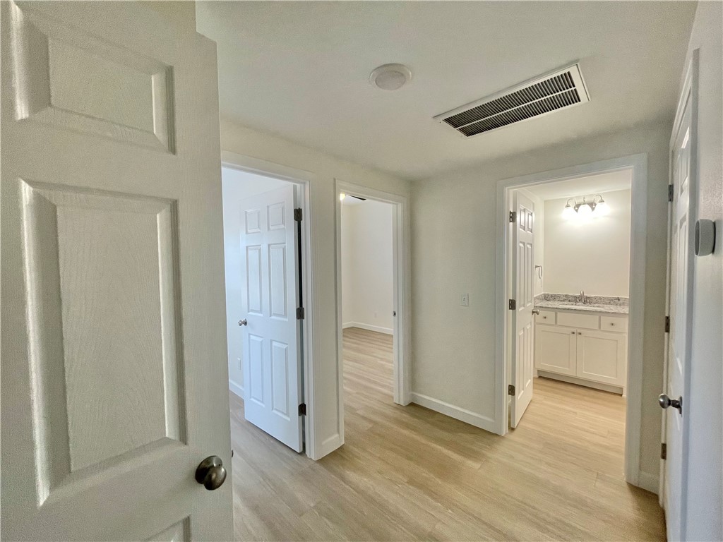 508 Park Street, Unit A Springdale, AR 72764 - Photo 7 of 7 Light wood-finish flooring extends through this interior hallway, featuring white paneled doors and trim