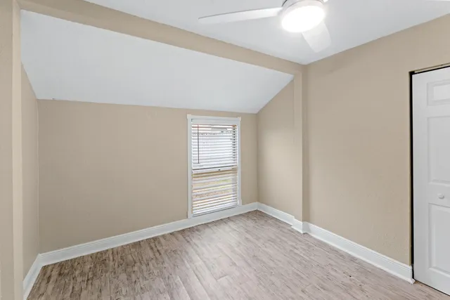 an empty room with wooden floor and mirror