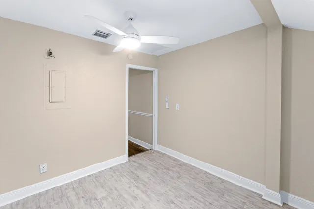 an empty room with a window and a fan