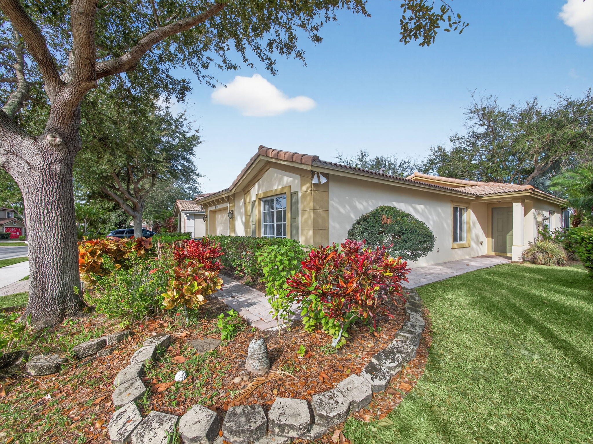 4358 Southeast Graham Drive Stuart, FL 34997 - Photo 2 of 38 a front view of a house with a garden and plants