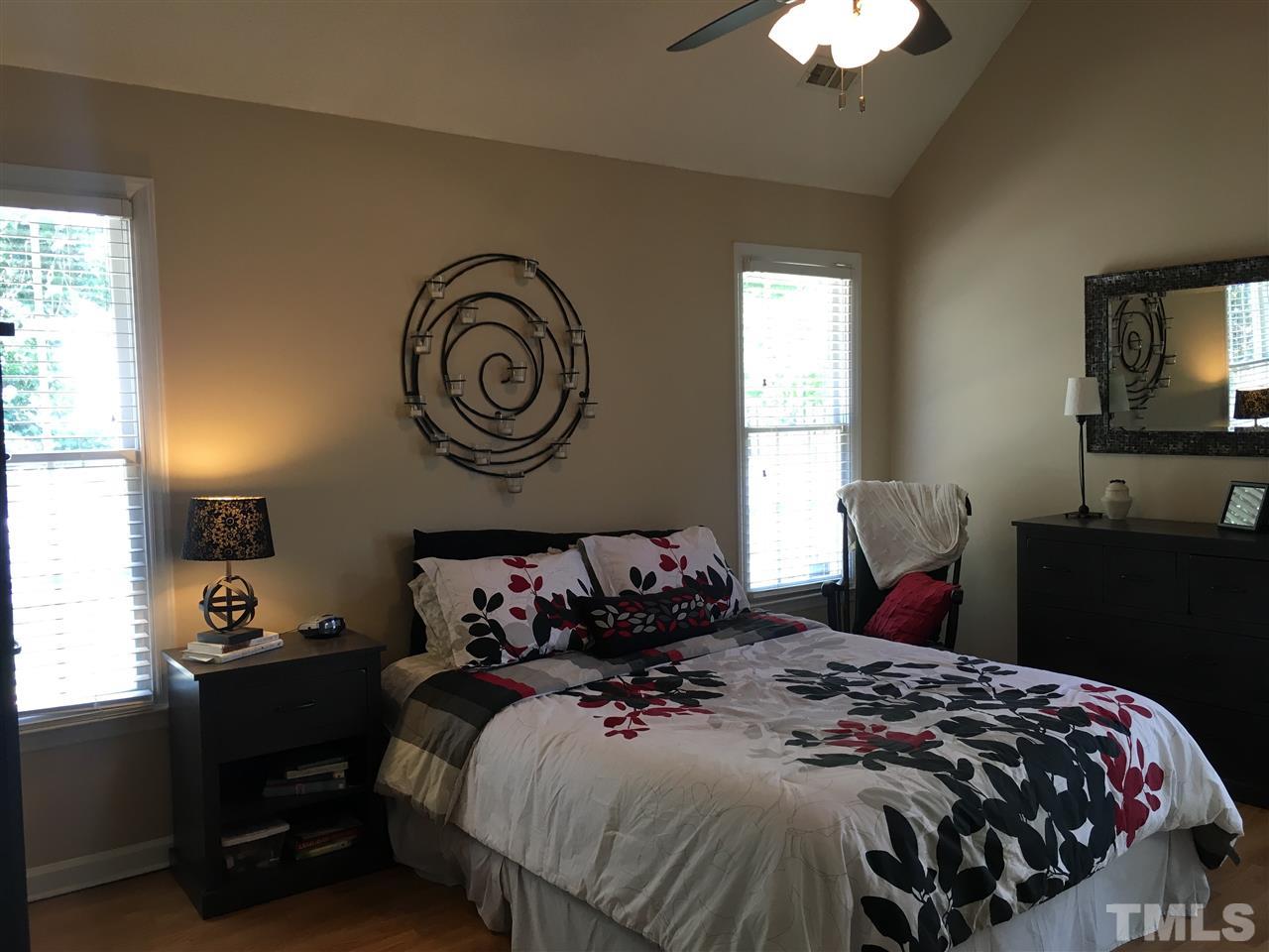 5208 Denmead Way Raleigh, NC 27613 - Photo 14 of 20 a bedroom with a bed and a chandelier