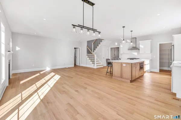 a view of a kitchen with stainless steel appliances wooden floor and a window